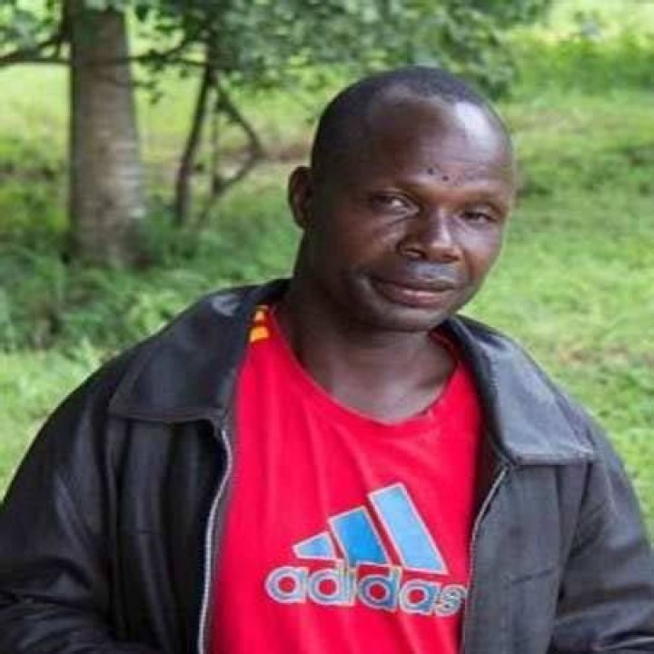 Adam Mwale is wearing a black jacket and a red adidas shirt.