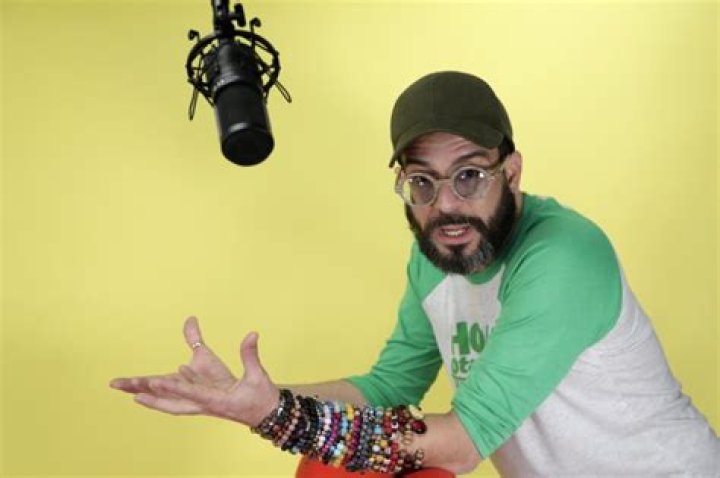 Alexander Otaola posing his both hands as if he is asking something wearing bangles.