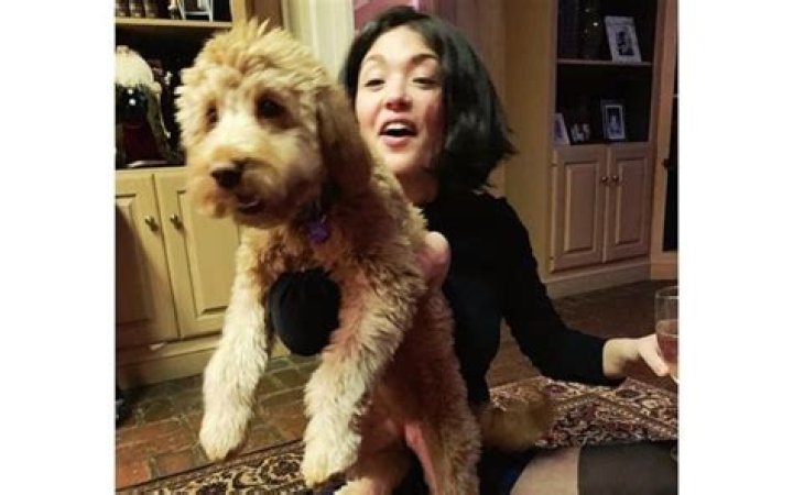 Ellen Tamaki with her pet in a black dress.