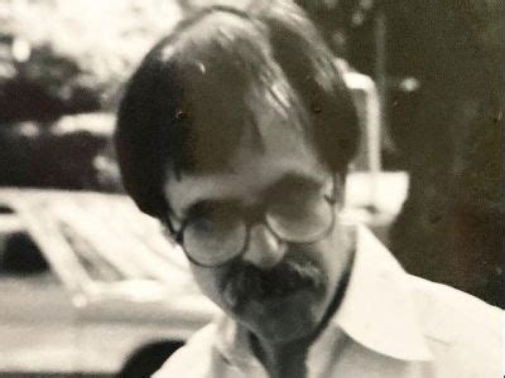 Glenn Cambor is wearing glasses and has a big mustache.