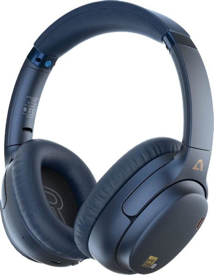 He is wearing a headphone while the controller is white themed dual shock 4.