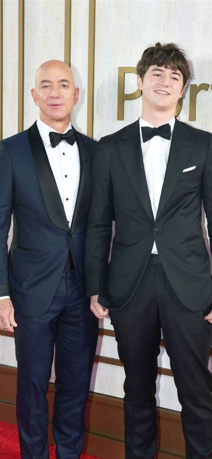 Jeff is wearing black coat with light grey pant. 