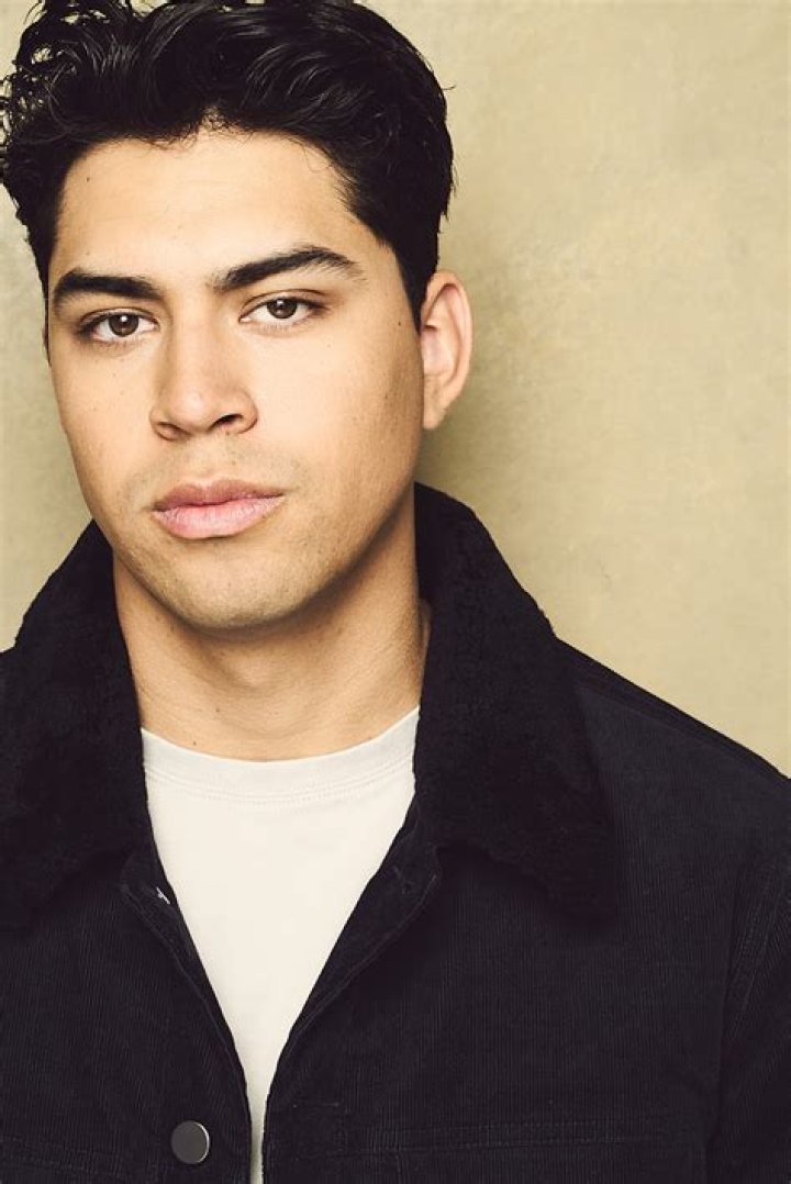 Niko Guardado is posing for the photo shoot by wearing black jacket sitting in a couch