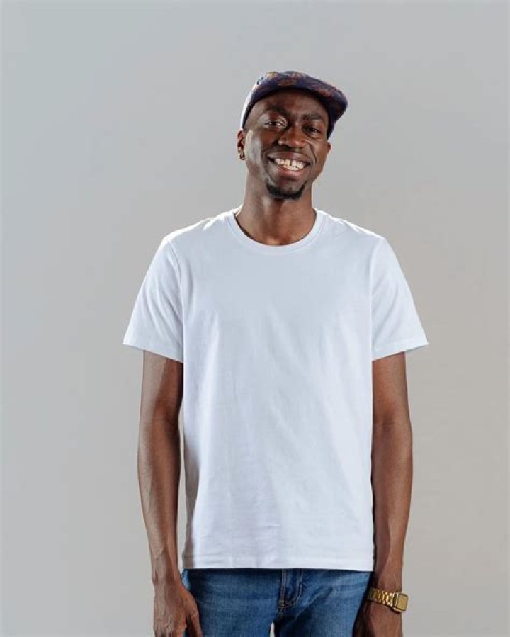 Olivier wearing a white t-shirt and a blue jeans.