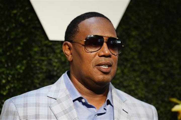 Percy Robert Miller Sr. in a light blue check coat and black shades.