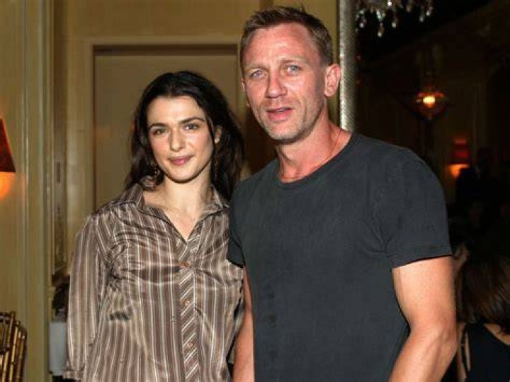 Rachel Weisz and Daniel Craig are walking with their baby in stroller.