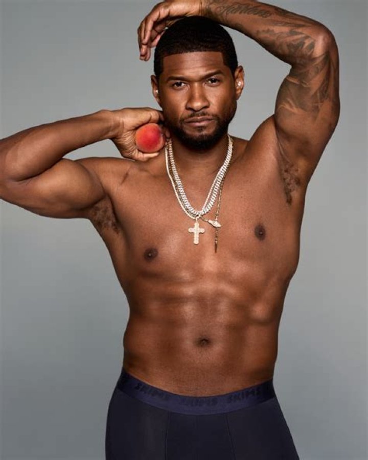 Usher Raymond IV posing in a black jacket, pants and goggles.