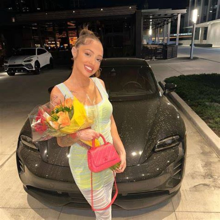 Victoria Waldrip posing with her car Tesla Model 3. 
